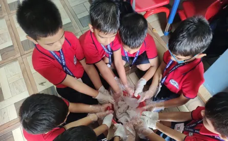 Joining hands to create newspaper bags